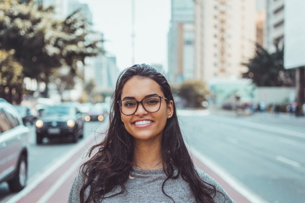 a girl standing on a street smiling