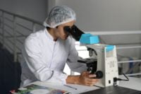 a guy is looking in the microscope