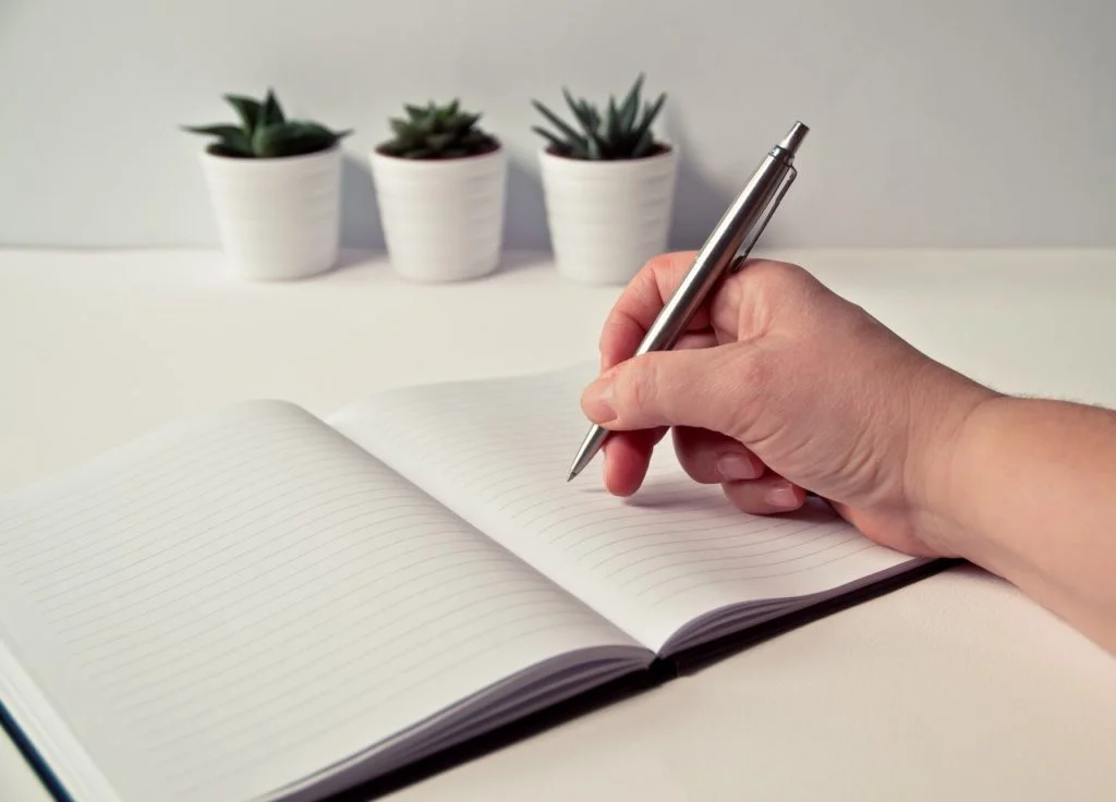 a hand is holding a pan over a blank page