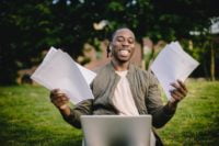 a guy with papers and a laptop in his hands