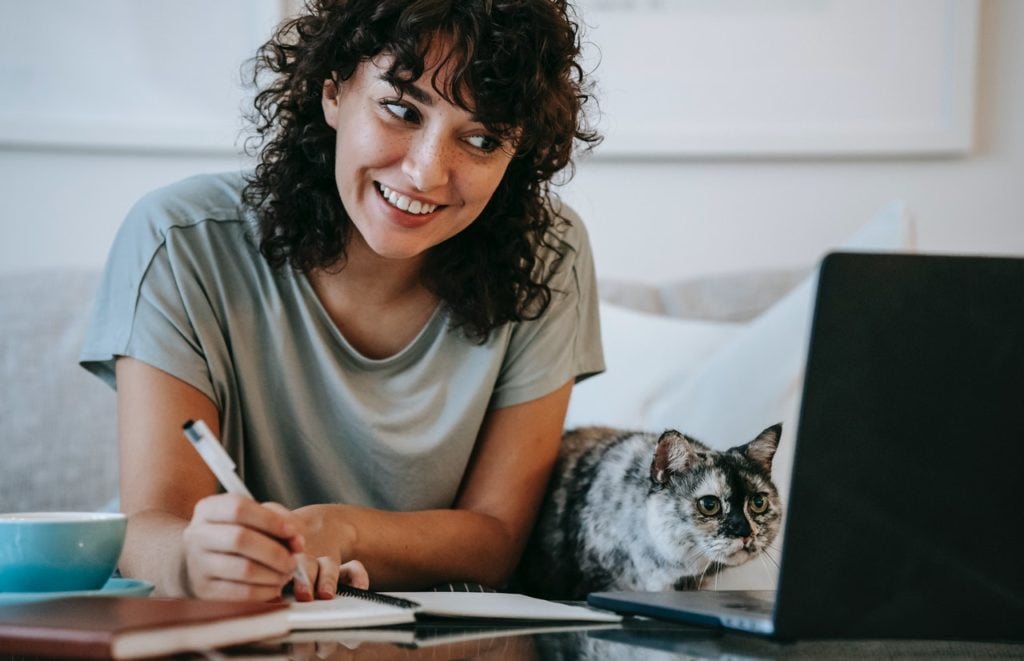 a girl with laptop and a cat