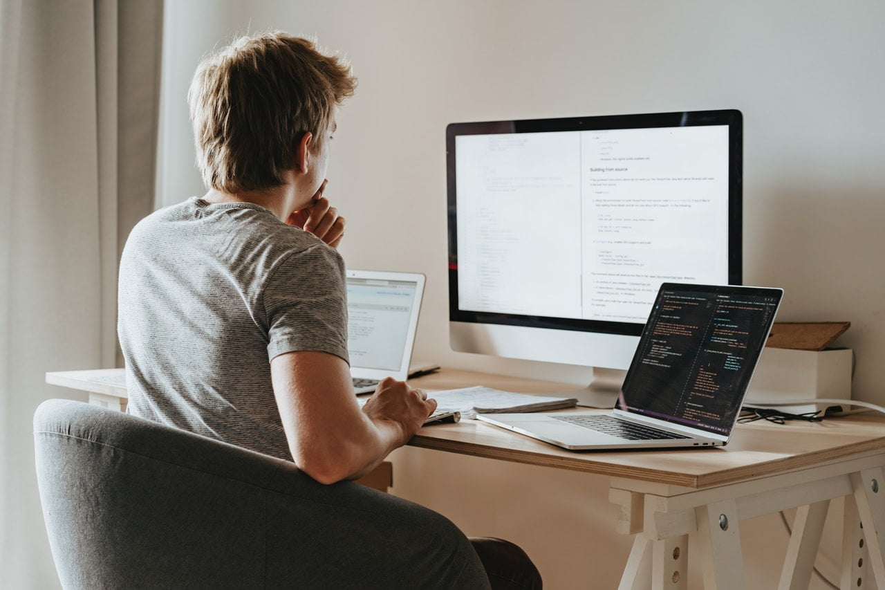 a guy is sitting in front of a computer screen