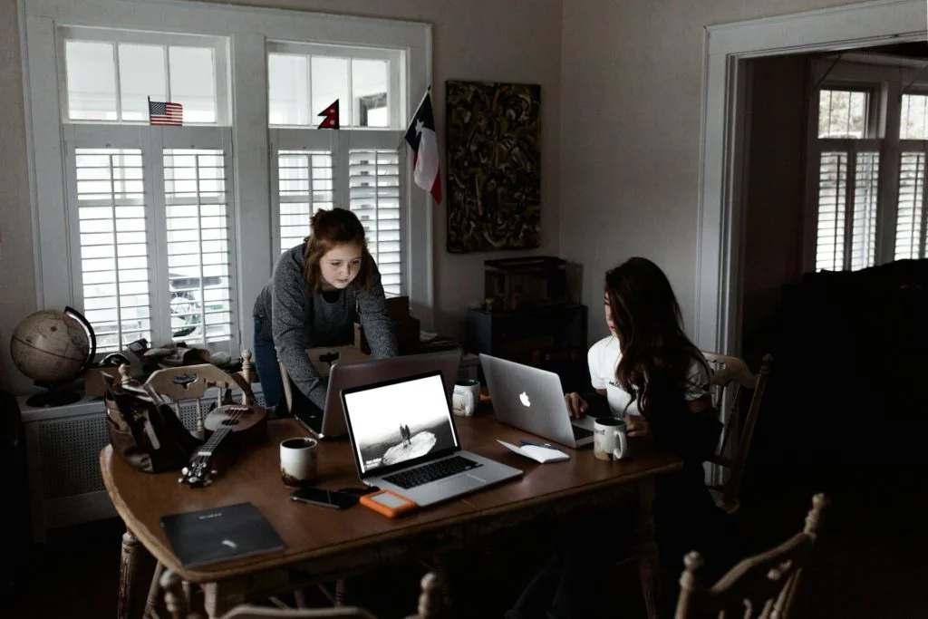 two girls with laptops